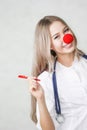 A pediatrician with a red nose