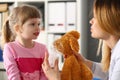 Pediatrician shows little girl on toy how to use oxygen mask Royalty Free Stock Photo