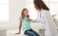 Pediatrician sounding little girl lungs in clinic Royalty Free Stock Photo