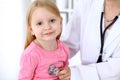 Pediatrician is taking care of baby in hospital. Little girl is being examine by doctor by stethoscope. Health care Royalty Free Stock Photo