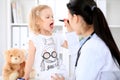 Pediatrician is taking care of baby in hospital. Little girl is being examine by doctor with stethoscope. Health care Royalty Free Stock Photo