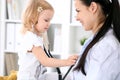 Pediatrician is taking care of baby in hospital. Little girl is being examine by doctor with stethoscope. Health care Royalty Free Stock Photo