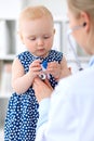 Pediatrician is taking care of baby in hospital. Little girl is being examine by doctor with stethoscope. Health care Royalty Free Stock Photo