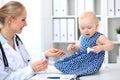 Pediatrician is taking care of baby in hospital. Little girl is being examine by doctor with stethoscope. Health care Royalty Free Stock Photo