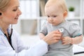 Pediatrician is taking care of baby in hospital. Little girl is being examine by doctor with stethoscope. Health care Royalty Free Stock Photo