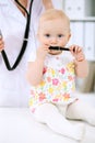 Pediatrician is taking care of baby in hospital. Little girl is being examine by doctor with stethoscope. Health care Royalty Free Stock Photo