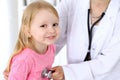 Pediatrician is taking care of baby in hospital. Little girl is being examine by doctor by stethoscope. Health care Royalty Free Stock Photo