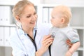 Pediatrician is taking care of baby in hospital. Little girl is being examine by doctor with stethoscope Royalty Free Stock Photo