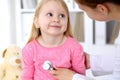 Pediatrician is taking care of baby in hospital. Little girl is being examine by doctor by stethoscope. Health care Royalty Free Stock Photo