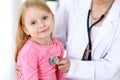 Pediatrician is taking care of baby in hospital. Little girl is being examine by doctor by stethoscope. Health care Royalty Free Stock Photo