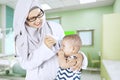 Pediatrician uses thermometer to check baby