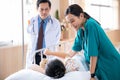 Pediatrician visiting parents and child in hospital bed ward Royalty Free Stock Photo