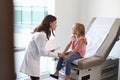 Pediatrician In White Coat With Child In Exam Room