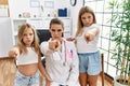 Pediatrician woman working at the clinic with two little girls pointing with finger to the camera and to you, confident gesture Royalty Free Stock Photo