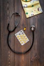 Pediatrics equipment with clothes, medicine wooden background top view