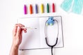 Pediatrics equipment with crayons, copybook white background top view space for text Royalty Free Stock Photo
