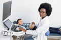 Pediatrics and regular medical examination. African American female doctor conducts an ultrasound scanning of the Royalty Free Stock Photo