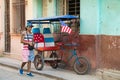 Pedicab, bikecab, velotaxi, cycle with flag of USA and seats , drivers shirt, cap, shorts with stars and stripes, Havana, Cuba.