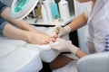 Pedicure dead skin remover foot rasp woman in nail salon. Application of the cream.