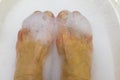 Pedicure, foot care. feet in foamy water