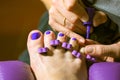 Pedicure master applies nail polish in beauty salon. Women& x27;s fingers toe divider