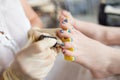 Pedicurist applying nail polish, close up photo