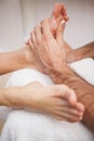 Pedicurist covering customers foot in soap