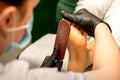 Pedicurist rubbing heel with a special grater on pedicure treatment in a beauty salon. Royalty Free Stock Photo