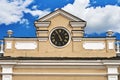 Pediment with a clock of an old Moscow building on the cloudy sky background