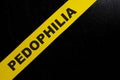 Pedophilia caution and warning concept. Yellow barricade tape with word in dark black background.