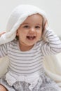 Peek-a-boo. Shot of a cute little baby girl sitting on the floor playing with her blanket. Royalty Free Stock Photo