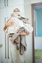 Peeking over the pile. Portrait of a young woman carrying a pile of laundry.