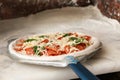 Peel with raw traditional Italian pizza on table Royalty Free Stock Photo