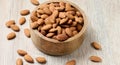 Peeled almond kernels in a round wooden plate on the table