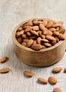 Peeled almond kernels in a round wooden plate on the table