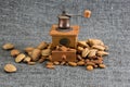 Peeled almonds in a white bowl on grey fabric texture, and an antique coffee grinder