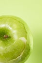 Peeled apple on green background