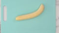 Peeled banana close up on blue cutting board, view from above Royalty Free Stock Photo