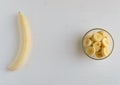 A peeled banana and a fresh ripe organic sliced bananas in a glass bowl. Royalty Free Stock Photo
