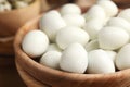 Peeled boiled quail eggs in wooden bowl, closeup