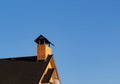 Peeled brick chimney on the roof top of the house, closeup