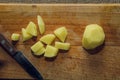 Peeled chopped potatoes on a wooden board.