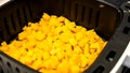 Peeled, diced potatoes for frying in the airfryer on a black background