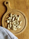 Peeled garlic cloves on chopping board and gray linen towel on old wooden background. Concept of cooking and folk medicine Royalty Free Stock Photo