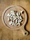 Peeled garlic cloves on chopping board on old wooden background. Concept of cooking and folk medicine for viral and colds. Royalty Free Stock Photo