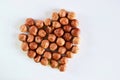 peeled hazelnuts are laid out in the shape of a heart on a light background with a place for an inscription.