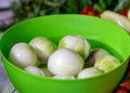Peeled onions in a green bowl, onions prepared for home preservation, autumn harvest time