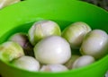 Peeled onions in a green bowl, onions prepared for home preservation, autumn harvest time