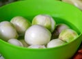 Peeled onions in a green bowl, onions prepared for home preservation, autumn harvest time