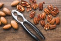 Peeled pecan nuts and nutcracker on wooden table. Top view